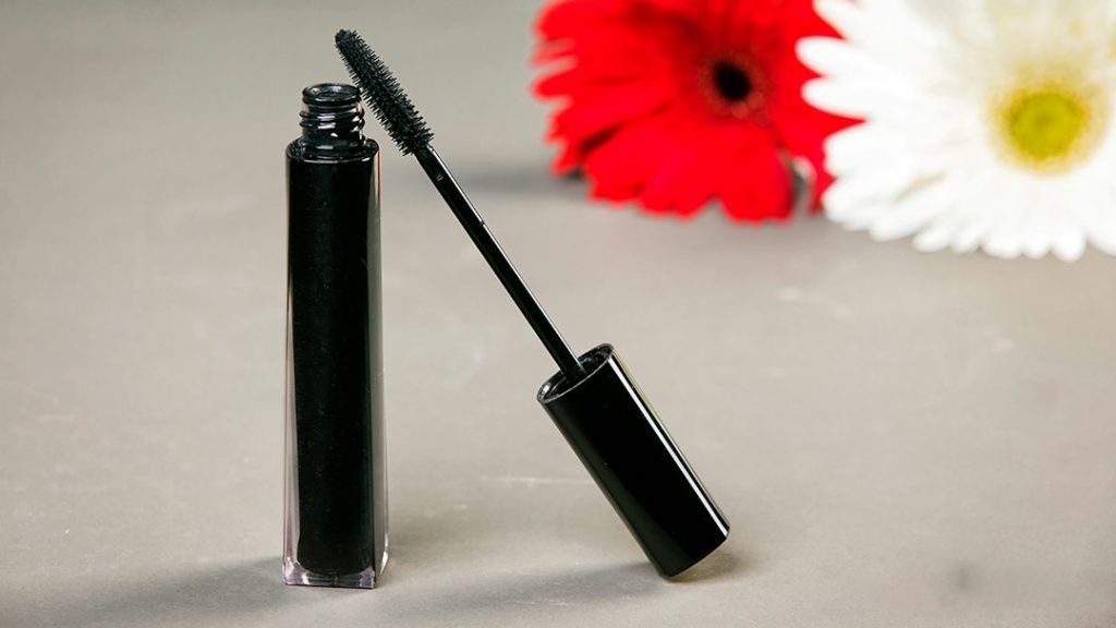 Black mascara tube and wand with flowers